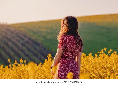 Portrait of young woman enjoying spring in a mustard field on sunny day - Powered by Shutterstock