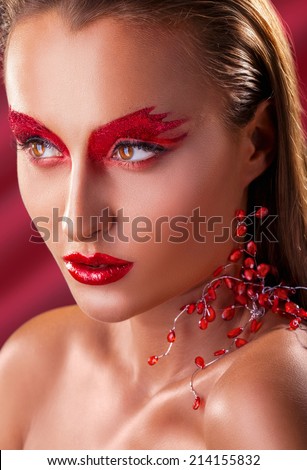 Portrait of young woman with fashion make-up on a red background