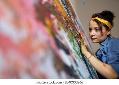 Portrait Of Young Woman, Female Painter Applying Paint On Canvas With Fingers While Creating A Large Modern Abstract Oil Painting