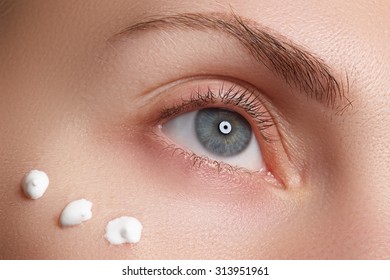 Portrait Of Young Woman With Fresh Clean Face With Points Of Moisturizing  Cream Under The Eye