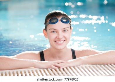 Portrait Of A Young Woman In Goggles In Swimming Pool