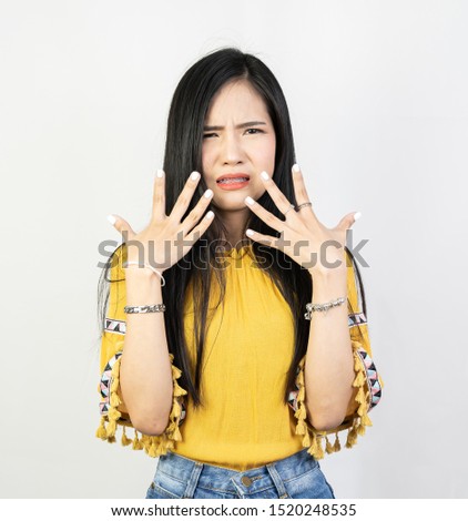 Portrait of young woman having hypersensitive teeth, posing on white background.