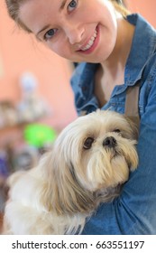 portrait of young woman and her dog in pet store