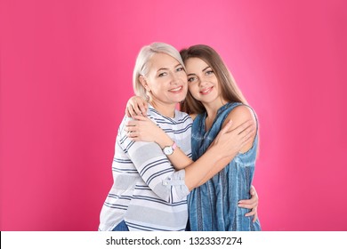 Portrait Of Young Woman With Her Mature Mother On Color Background