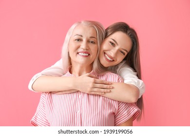 Portrait Of Young Woman And Her Mother On Color Background