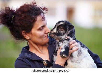 Portrait Of A Young Woman Holding A Baby Goat Outdoor