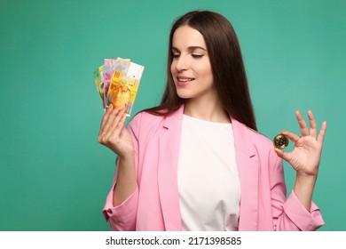 Portrait of young woman holding bitcoin and swedish krona banknotes and looking at swedish krona