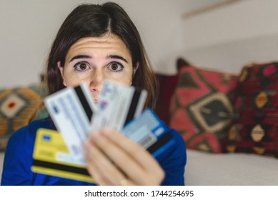 Portrait Young Woman Holding Credit Cards. Worried Face And Scared Eyes Because Too Much Expanses Or Internet Scam During Online Shopping. Debts, Technology, Home Banking O Fraud Concept.