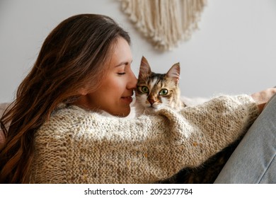Portrait of young woman holding cute siberian cat with green eyes. Female hugging her cute long hair kitty. Background, copy space, close up. Adorable domestic pet concept. - Shutterstock ID 2092377784