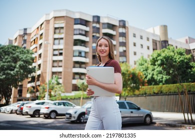 Portrait Of Young Woman Holding Folders. She Is Walking On The Street Going To College.