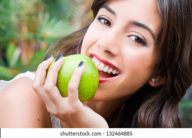 Porträt einer jungen Frau, die einen grünen Apfel hält