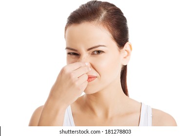 Portrait Of A Young Woman Holding Her Nose Because Of A Bad Smell. 