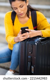 Portrait Young Woman Holding Mobile Phone By Suitcase 