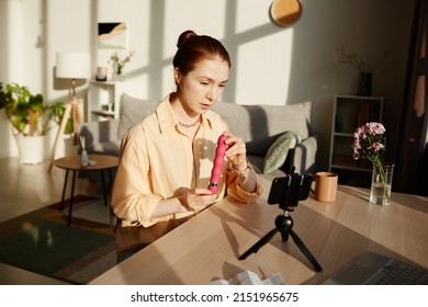 Portrait Of Young Woman Holding Pink Vibrator While Filming Sex Toy Review At Home For Online Education , Copy Space