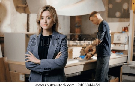 Portrait young woman in jacket on background of wood workshop, making furniture from chipboard, small Business concept.