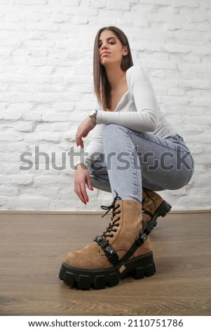 Portrait of young woman in jeans and suede chunky boots