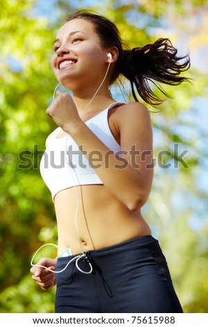 Portrait of a young woman jogging with a walkman