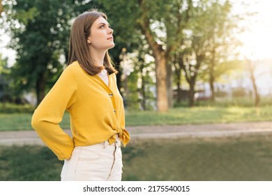 Portrait Of Young Woman With Long Hair Open Eyes Looking Feel Happy The Day Sun Is Shining And The Wind Blow. Gorgeous Woman Looking Thoughtfully To The Sky.