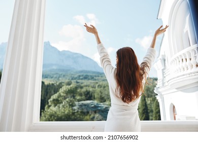 Portrait of young woman looks at a beautiful view from the balcony unaltered