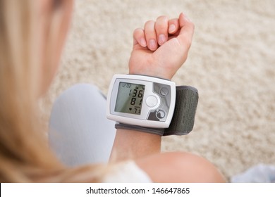 Portrait of young woman measuring her blood pressure