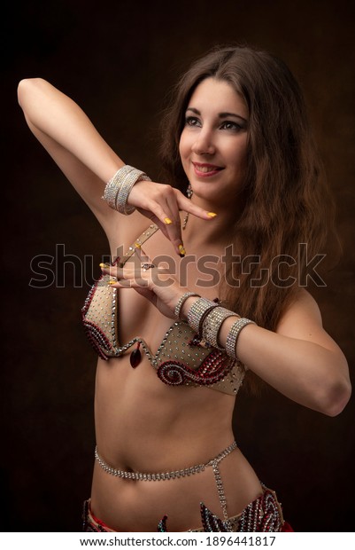 Portrait of a young woman in oriental\
costume. Belly dance. Oriental dance. The\
brunette.