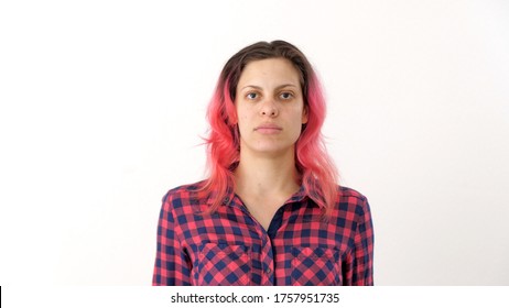 Portrait of young woman with pink hair in a plaid shirt. Sweet adult girl poses for photographer for passport photo. Portraits of people. Calm female human looking at the camera