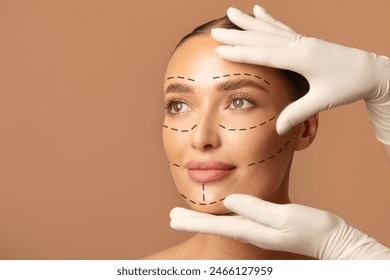 Portrait of young woman and plastic surgeon making marks on female face over beige studio background, preparing for facelifting procedure - Powered by Shutterstock