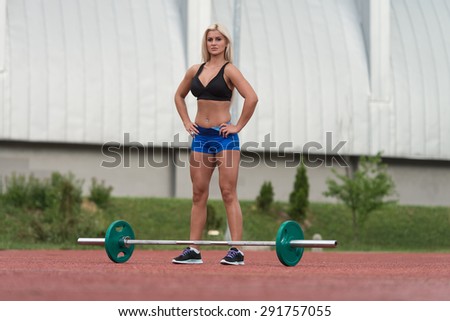 Portrait Of A Young Woman Preparing For Dead Lift Exercise Outdoor