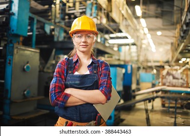 Portrait of young woman in protective glasses in the factory