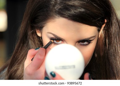 Portrait Of Young Woman Putting Make Up On