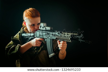 Portrait of young woman with red hair, young girl takes aim at the sight in military uniform, Horizontal photo