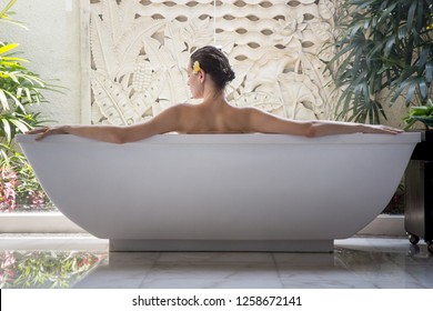 Portrait of a young woman relaxing in the bathtub, organic skin-care at the luxury hotel spa, wellbeing and self-care concept