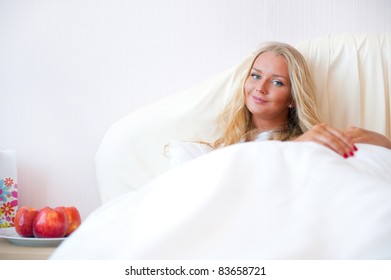 Portrait Of Young Woman Relaxing On Bed