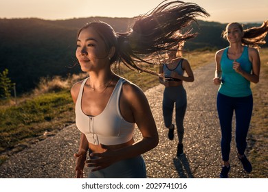 Portrait of young woman running with her friends outdoors. - Powered by Shutterstock