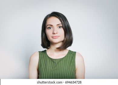 Portrait Of Young Woman With A Serious Face, Isolated On A Gray Background