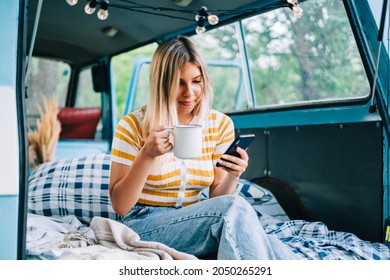 Portrait of young woman sitting in a van and using mobile phone, outdoors in nature. Enjoying summer, travel concept - Powered by Shutterstock