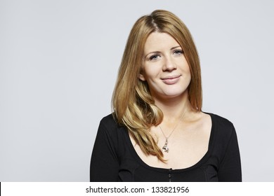 Portrait Of A Young Woman Smiling On Plain Background