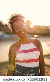 Portrait of young woman smiling outdoors at sunset
