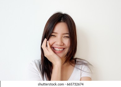 Portrait Of A Young Woman Smiling With Pink Braces, White Background, Happy Concept, Asian