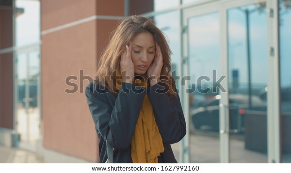 Portrait young woman stand with headache look at\
camera sneezing feel sick at outdoor fever cold allergy city\
beautiful disease female nose lady runny tissue adult illness\
district slow motion