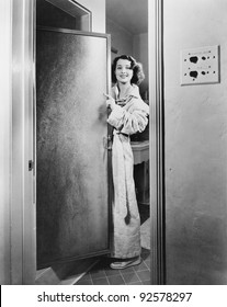 Portrait Of A Young Woman Standing At A Door Of A Bathroom