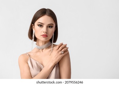 Portrait of young woman with stylish jewelry on white background on white background