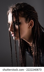 Portrait Of Young Woman With Stylish Makeup And Dreadlocks Isolated On Grey