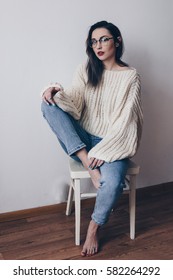 Portrait Of Young Woman In Stylish Oversized Sweater And Mom Jeans