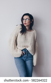 Portrait Of Young Woman In Stylish Oversized Sweater And Mom Jeans