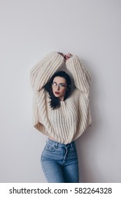 Portrait Of Young Woman In Stylish Oversized Sweater And Mom Jeans