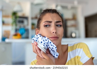 Portrait Of Young Woman Suffering From Toothache, Cooling Her Face With A Ice Pack