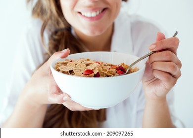 Portrait of young woman in underwear eating cereals. Isolated on white. - Shutterstock ID 209097265