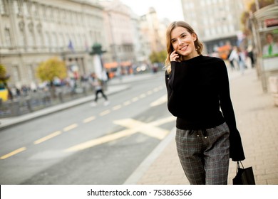 Portrait Of Young Woman Waiting For Taxi Or Bus On The Street In The City