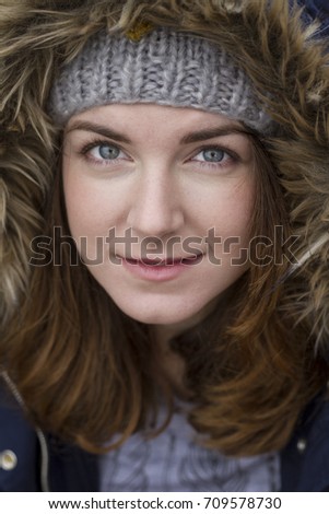 Portrait of a young woman wearing hood in autumn. Soft focus